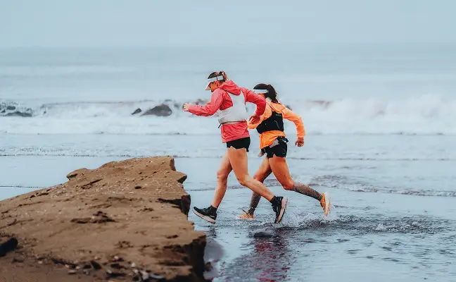 Two trail runners running together along a rocky coastal route